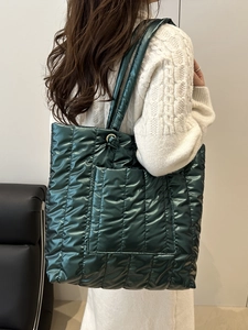 Quilted green puffer tote bag made of metallic nylon fabric for winter commuter style