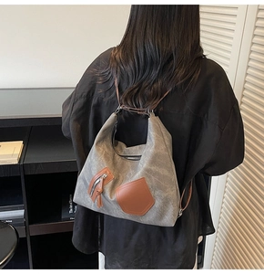 Detail of gray canvas backpack with brown leather tassels and premium metal hardware