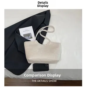 Macro detail of creamy woven texture and refined stitching on a stylish tote bag