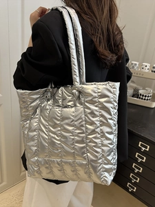 Silver quilted puffer tote bag with large capacity and minimalist metallic finish for women