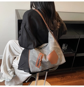 Detail of vintage canvas hobo bag showing retro grey texture and leather strap accents