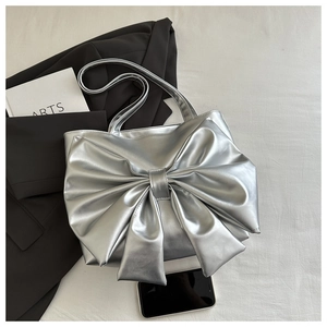 Detailed close-up of large bow design on silver metallic tote bag with sleek texture