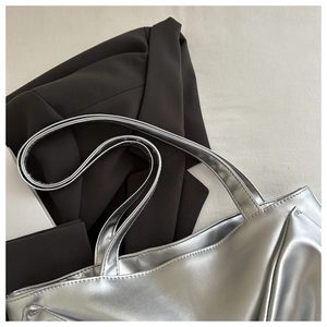Close-up of silver tote bag showing metallic PU leather texture and ribbon detail