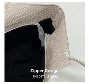 Detail view of large tote bag with smooth zipper closure and woven texture design