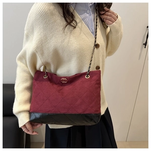 Détail du sac matelassé bordeaux avec chaîne dorée et base en cuir noir