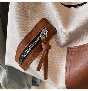 Detail of woven fabric texture with brown faux leather pocket and zip on a tote bag