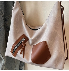 Detail of vintage grey canvas tote bag with brown leather pocket and zipper accents