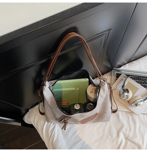 Detailed interior view of a large grey hobo bag showing capacity for tablets and daily items