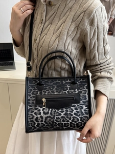 Fashionable black and white leopard print tote bag with dual handles and crossbody strap