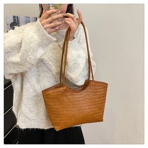 Detail of the brown woven tote bag with herringbone pattern and wavy edge design