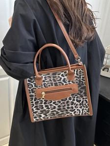 Trendy leopard print tote bag with brown leather trim and adjustable shoulder strap