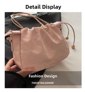 Dettaglio borsa a nuvola plissettata rosa con tracolla a catena dorata e coulisse