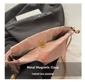 Dettaglio della chiusura magnetica dorata sulla borsa a secchiello in pelle rosa