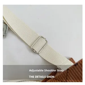 Detail of adjustable shoulder strap with silver buckle on brown corduroy bag