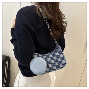 Detail of blue checkerboard denim shoulder bag with frayed edges on female model