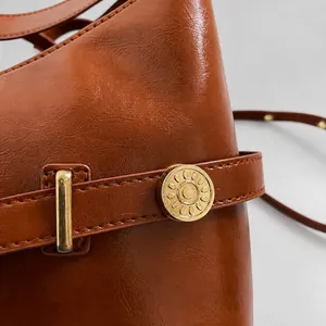 Detailed macro view of the brown leather texture and elegant golden metal hardware accents