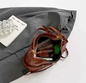 Vue de dessus de l'intérieur spacieux du sac en cuir marron avec cosmétiques divers