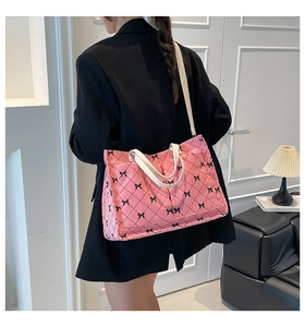Detailed back view of a pink corduroy tote bag featuring black bow prints and durable straps