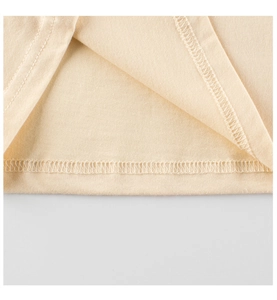 Vue macro de l'ourlet à double couture et texture coton sur t-shirt pour filles