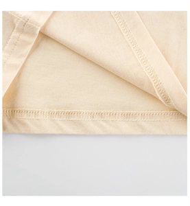 Macro detail of fine double-needle stitching on beige cotton girl's summer t-shirt
