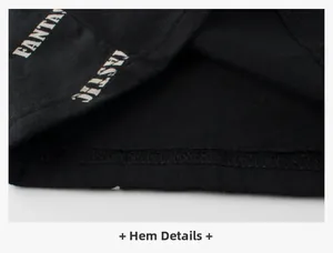 Détail de l'ourlet d'un t-shirt noir en coton pour enfant avec imprimé blanc et coutures nettes