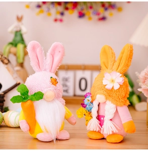 Détail de gnomes de Pâques en peluche avec carotte et fleurs sur une table en bois