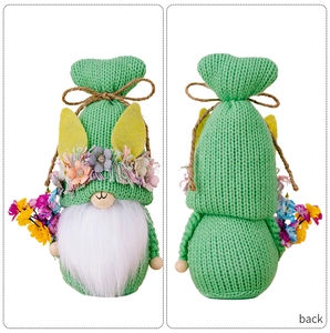 Front and back views of a green knitted Easter gnome with rabbit ears and floral details