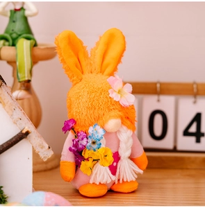Détail d'un gnome de Pâques en peluche avec oreilles de lapin et fleurs sur un bureau