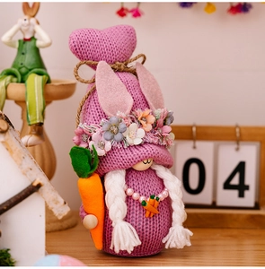 Detail of purple knitted Easter gnome doll featuring long braids and felt carrot decoration
