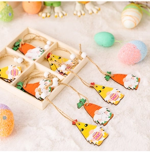 Gros plan d'ornements de Pâques en bois avec gnomes et carottes dans une boîte