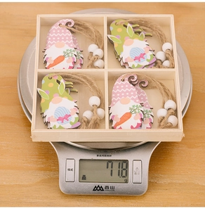 Ornements de Pâques en bois dans leur boîte pesant 71,8g sur une balance de cuisine
