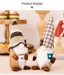 Detail of two coffee-themed gnomes with striped and checkered hats in a cozy home setting