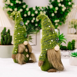 Close-up of green knitted gnome figurines with succulent plant details and fuzzy beards
