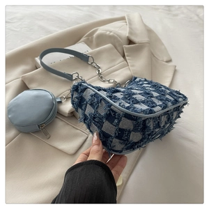 Detail of blue denim checkerboard shoulder bag with round mini coin purse and chain strap