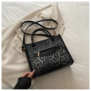 Detail of leopard print tote bag with gold zipper pocket and adjustable strap