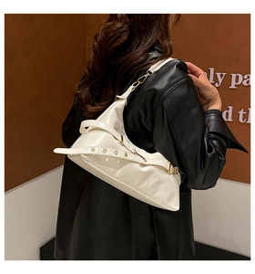 Détail du sac sous le bras blanc brillant avec œillets métalliques dorés sur la sangle