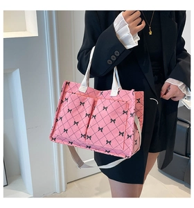 Detail of pink corduroy tote bag with black bow patterns and external magnetic pockets