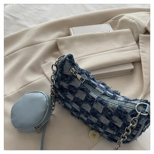Close-up of blue checkered canvas tote with fringe texture and small round coin purse