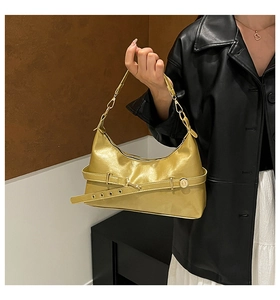 Détail du sac doré métallisé avec boucle décorative et bandoulière amovible réglable