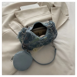 Internal view of blue denim shoulder bag with mini round pouch and chain strap detail