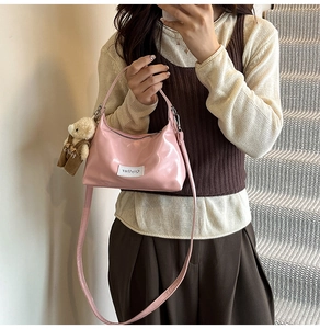 Pink patent leather crossbody cloud bag with a cute teddy bear charm accessory