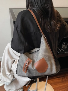 Retro large canvas hobo bag with brown leather pockets shown on model in a modern room