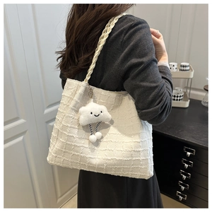Détail du sac cabas en tweed crème avec pendentif nuage en peluche et bandoulière tissée