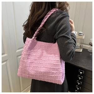 Pink tote bag detail with 3D bubble texture and woven straps shown in a lifestyle setting