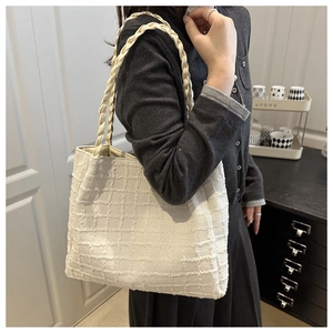 Détail du sac cabas en tweed blanc avec double anse tressée porté à l'épaule