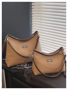 Größenvergleich brauner Canvas-Halbmond-Taschen mit Lederbesatz bei natürlichem Licht