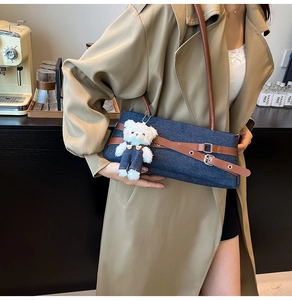 Détail du sac à épaule en jean avec lanières en cuir et breloque ours en peluche mignonne
