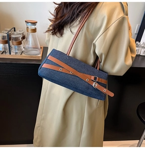 Vue détaillée du sac en jean avec lanières en cuir marron et détails de boucles en métal