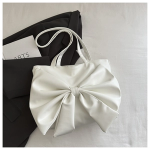 Dettaglio borsa tote bianca con fiocco in morbida pelle PU su sfondo minimalista
