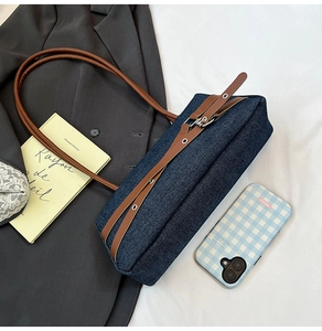 Gros plan du sac bandoulière en denim avec bandoulière en cuir et boucle